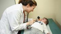 Female pediatrician examines baby.